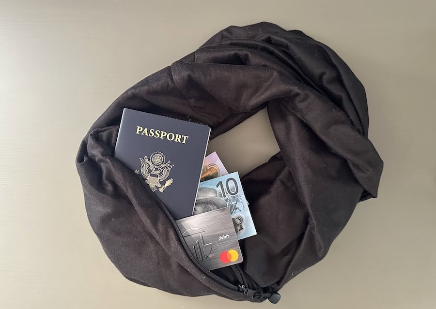 Black infinity travel scarf with passport, debit card, and cash in the hidden pocket.